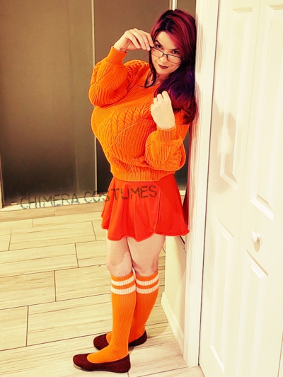 Explore the cheeky side of Velma from Scooby-Doo with Chimera Costumes' busty cosplay—where mystery-solving meets playful allure. 