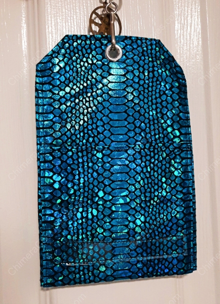 A detailed view of a badge holder exhibiting a combination of dragon scale motifs and nerdy sci-fi fabrics.