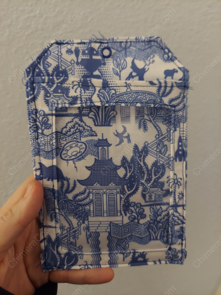 A creatively designed badge holder featuring a blend of nerdy sci-fi fabrics and intricate dragon scale patterns.